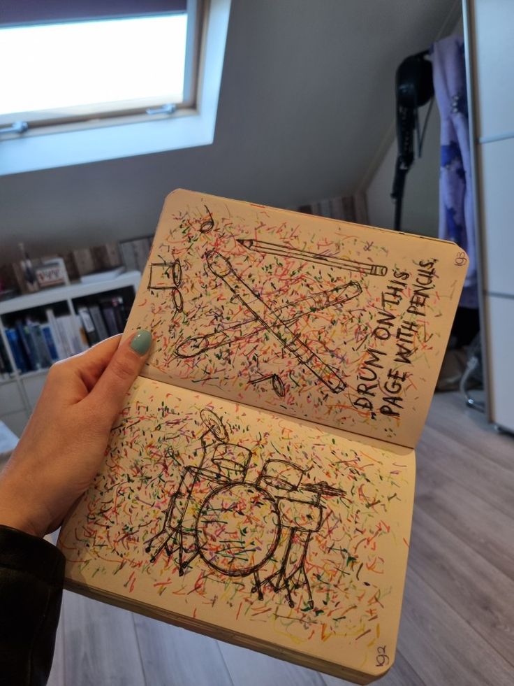 someone is holding up an open book with writing on it and the pages are covered in sprinkles