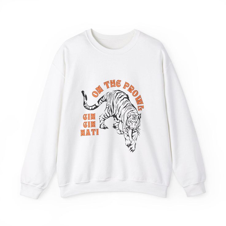 Get ready to cheer on the Cincinnati Bengals in style with our exclusive "On the Prowl" unisex sweatshirt! Whether you're heading to the game, watching from home, or just want to show off your Bengals pride, this cozy sweatshirt is the perfect addition to your wardrobe. Design: Bold "On the Prowl" graphic that captures the spirit of the Bengals. Perfect for fans who live and breathe football! Available in white and gray. If you want another color combination, send me a message! Inspiration: Inspired by the Cincinnati Bengals' iconic fight song, this sweatshirt embodies the energy and excitement of game day. Unisex Fit: Designed to look great on everyone. This sweatshirt offers a comfortable, relaxed fit that's perfect for layering or wearing on its own. --- Ideal for any situation, a unise White Team Spirit Sweatshirt With Graphic Print, White Slogan Sweater For Streetwear, White Screen Print Sweatshirt For Fan Gear, White Graphic Print Team Spirit Sweatshirt, Oversized Graphic Print Sweatshirt Fan Apparel, Cute Bengals Outfit, Streetwear White Slogan Sweater, White Band Merch Sweatshirt, White Screen Print Band Merch Sweatshirt