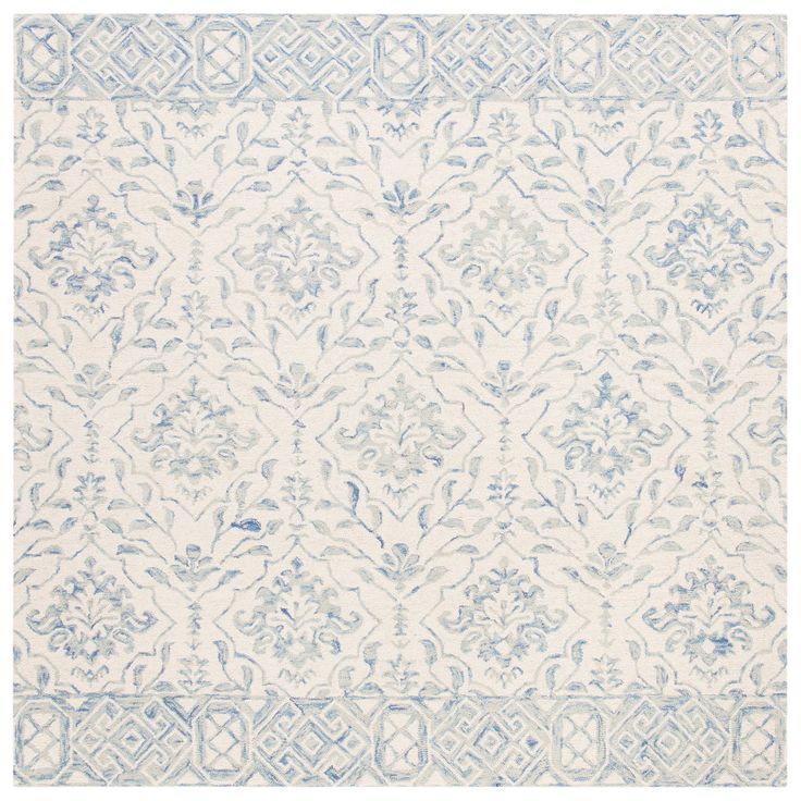 a blue and white rug with an intricate design on the bottom, in front of a white background