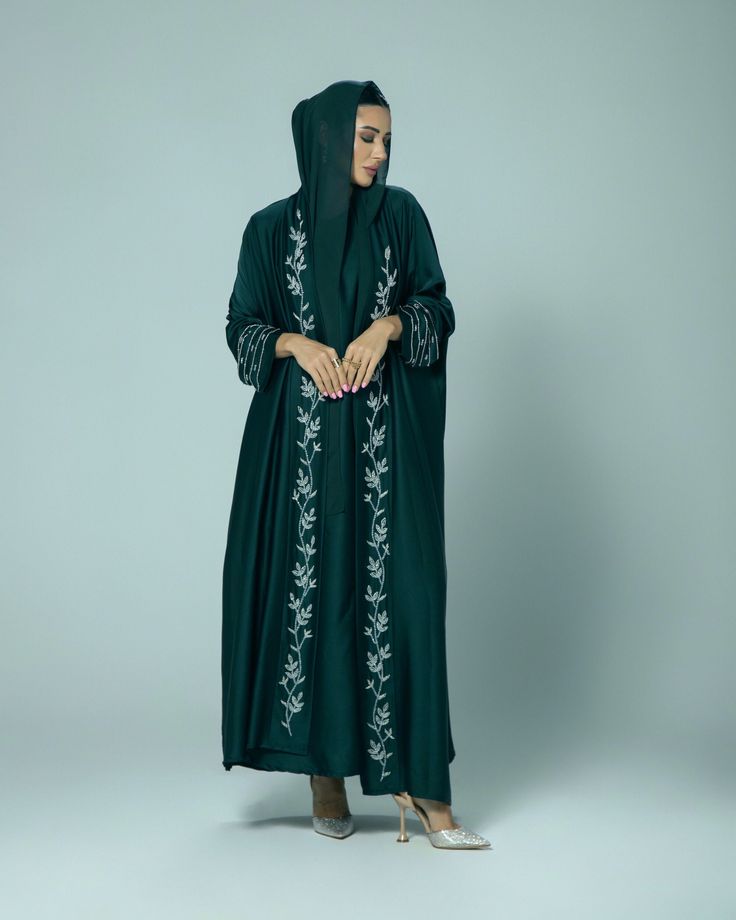 (Estimated delivery for pre-orders: 10/02/25 - 14/02/25. If you require a quicker delivery, please contact us). Giving elegant modesty, the 'Amani' abaya is perfect for all occasions. The satin fabric gracefully flows and is adorned with hand embellished intricate beading on the cuffs and collar. - Scarf and slip dress included. - Dry clean only. - Cool iron. - Colours may vary. - Model is 5'6 wearing size 54. Elegant Long Sleeve Abaya With Embroidered Border, Formal Abaya With Dabka Work For Eid, Formal Eid Abaya With Dabka Work, Green Abaya With Dabka Work, Hand Embellished Long Sleeve Kaftan For Eid, Elegant Green Embroidered Thobe, Elegant Green Embroidered Abaya, Eid Embellished Green Abaya, Elegant Embroidered Green Abaya