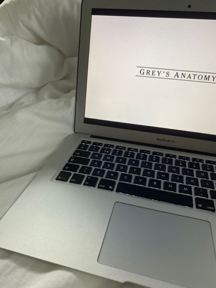 an open laptop computer sitting on top of a bed