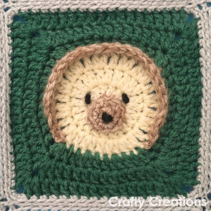 a crocheted square with a bear's face in the center on top