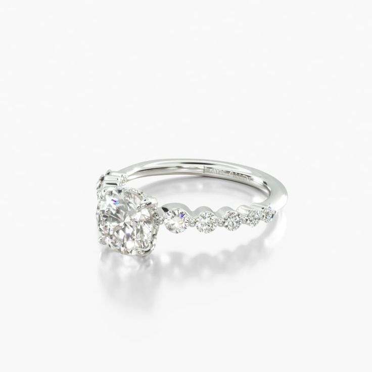 a white gold ring with an oval diamond in the center and side stones on each band