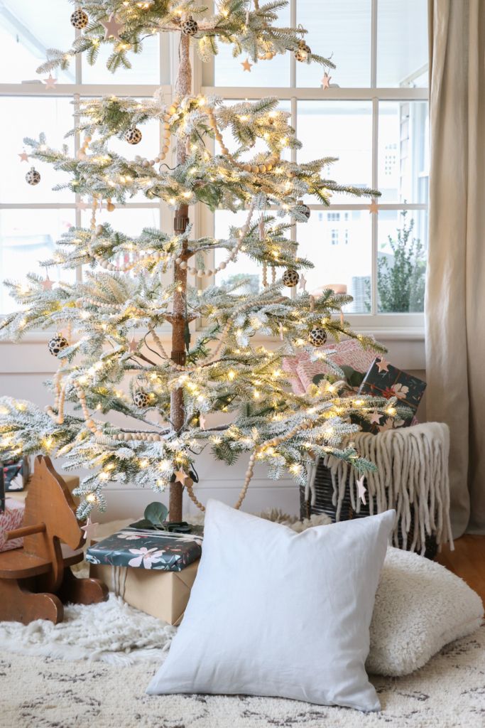 a white christmas tree in front of a window