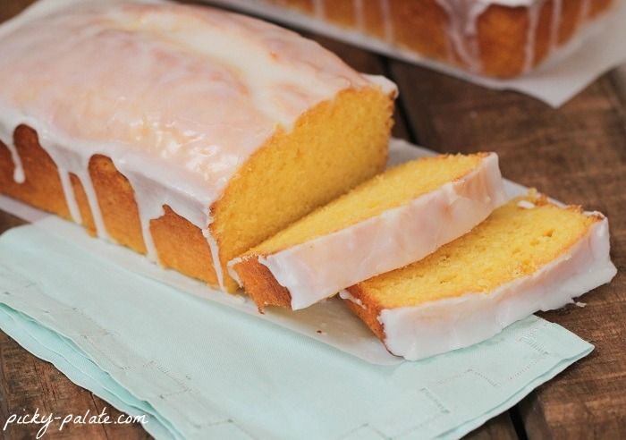 a loaf of lemon pound cake sitting on top of a white plate with frosting