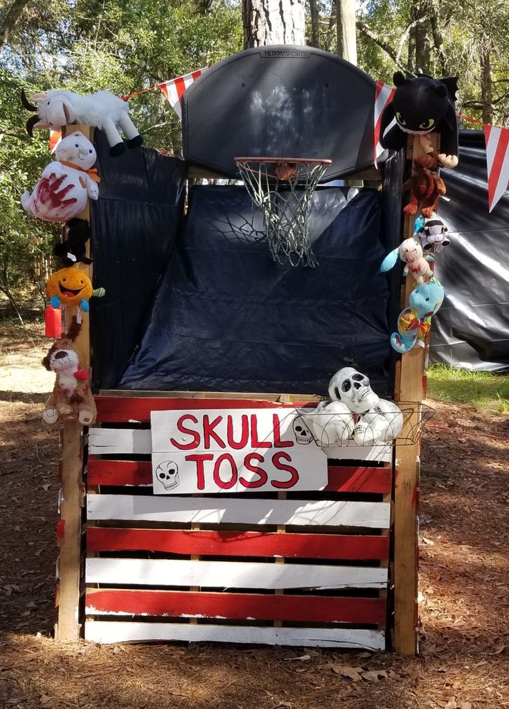 an outdoor basketball goal with stuffed animals and toys on the top, attached to it