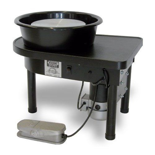 a black stove with a white bowl on it and a gray object next to it