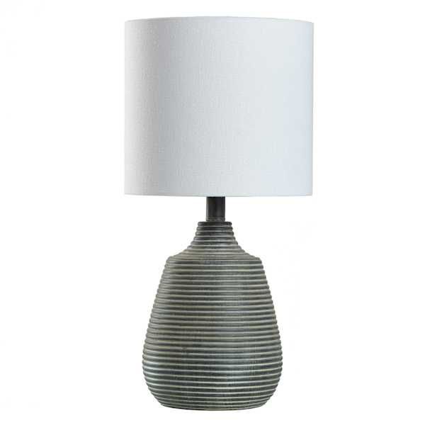 a lamp with a white shade on the base and a black stripe pattern around it