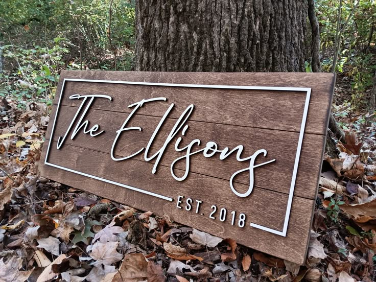 a wooden sign that says the ellfsons on it in front of a tree