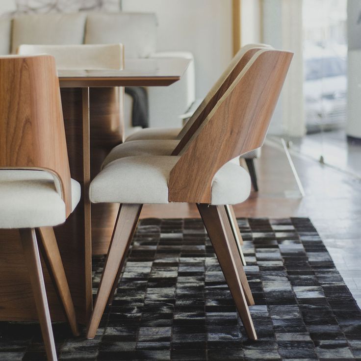 a dining room table with two chairs and a rug on the floor in front of it