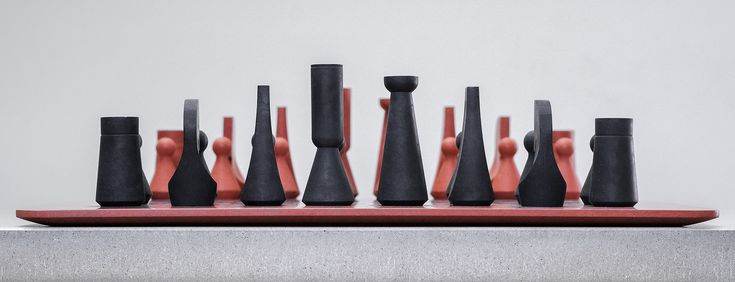 an assortment of black and red vases sitting on top of a table