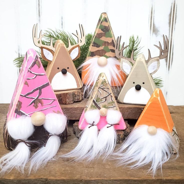 several different types of christmas decorations on a wooden table with pine cones and deer antlers