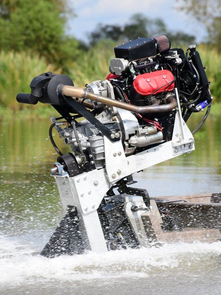 an engine is attached to the back of a boat in some water with trees in the background