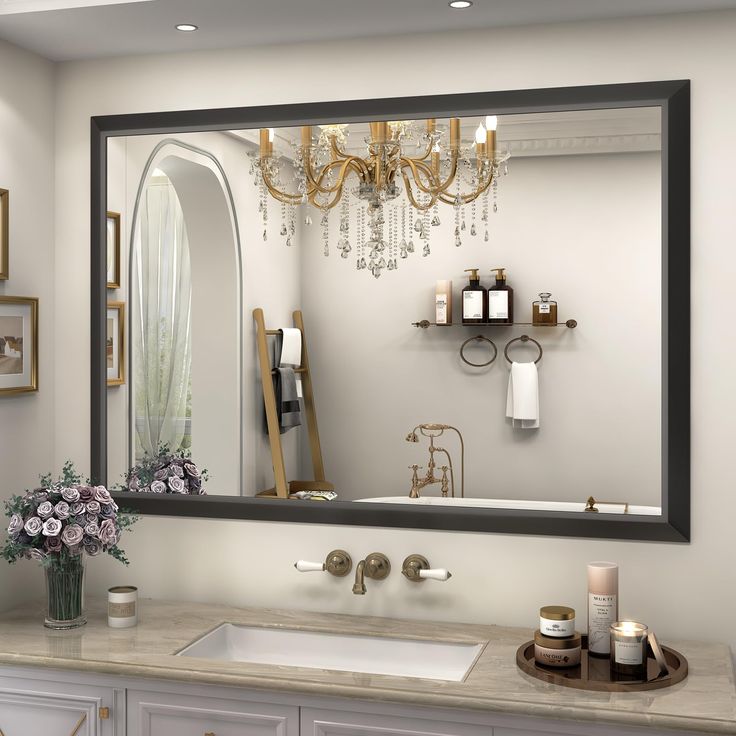 a bathroom with a sink, mirror and chandelier in the middle of it