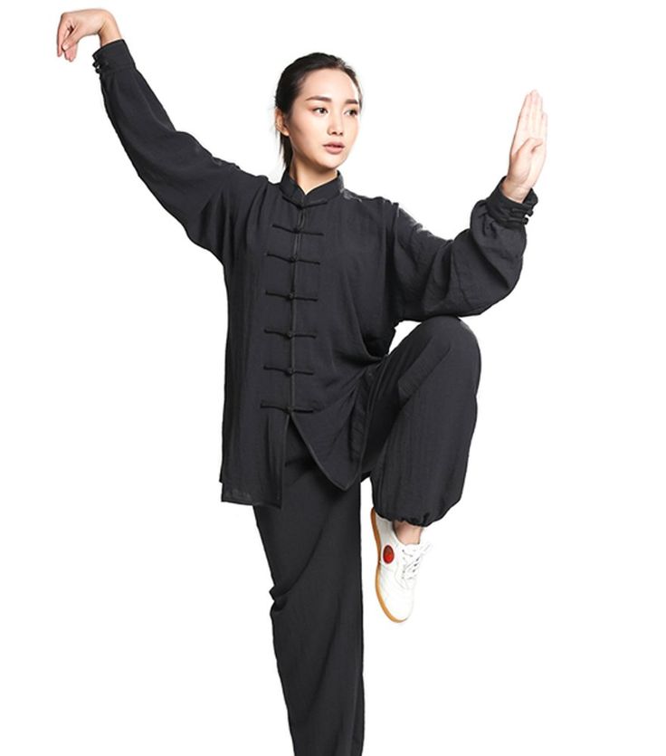 a woman in black is doing a dance move with her arms up and legs spread out