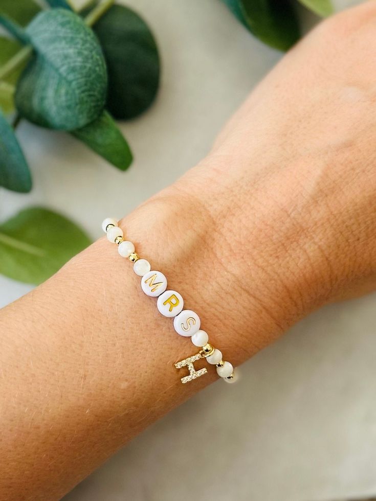 This bride bracelet with dainty initial-to-be and is a sweet and fun personalized gift for the future bride. Perfect gift for bride at bachelorette party or bridal shower. Beaded with genuine mother of pearl and 18k gold filled beads that are tarnish resistant and made to last opposed to the more commonly seen gold plated. Other coordinating pieces in shop. Beaded on high quality stretch cord and secured..     3mm 18k gold filled beads   4mm mother of pearl beads   7mm gold filled initial with cubic zirconia   acrylic letter beads    - Each purchase is sent in a drawstring velvet jewelry bag, making the perfect bride bracelet gift, bridal shower gift, bachelorette gift, just for yourself. Gift boxes are an available  option in shop listings, just add to cart. - To care for your bracelet, p Bachelorette Bracelets, Bachelorette Gift For Bride, Bachelorette Bride Gifts, Bride Bracelet, Pearl Bride, Bachelorette Gift, Perfect Bride, Acrylic Letters, Personalized Bride