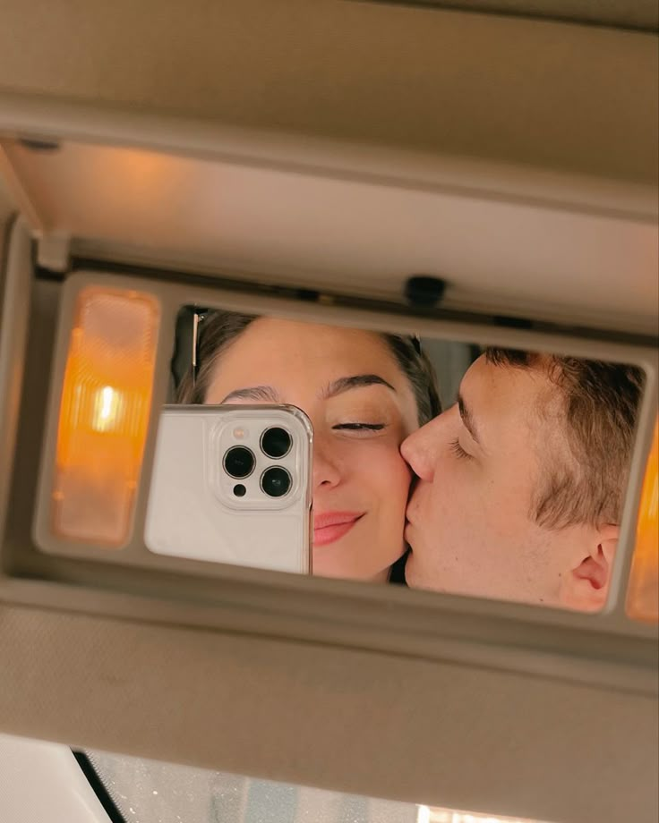 a man and woman taking a selfie in the mirror with their cell phone camera