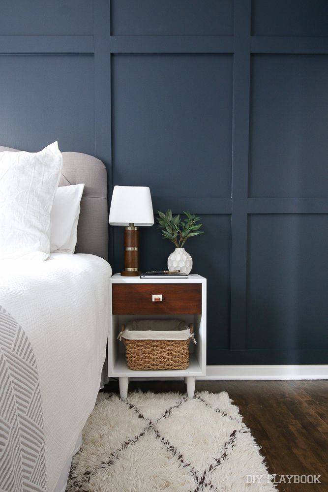 a bedroom with blue walls and white bedding