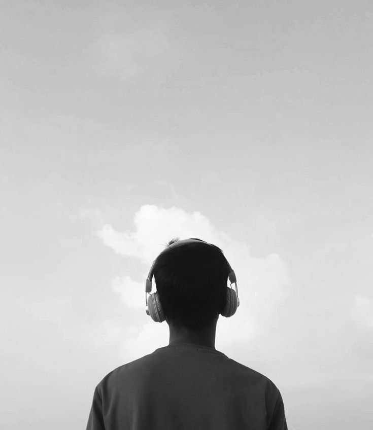 a man with headphones looking at the sky