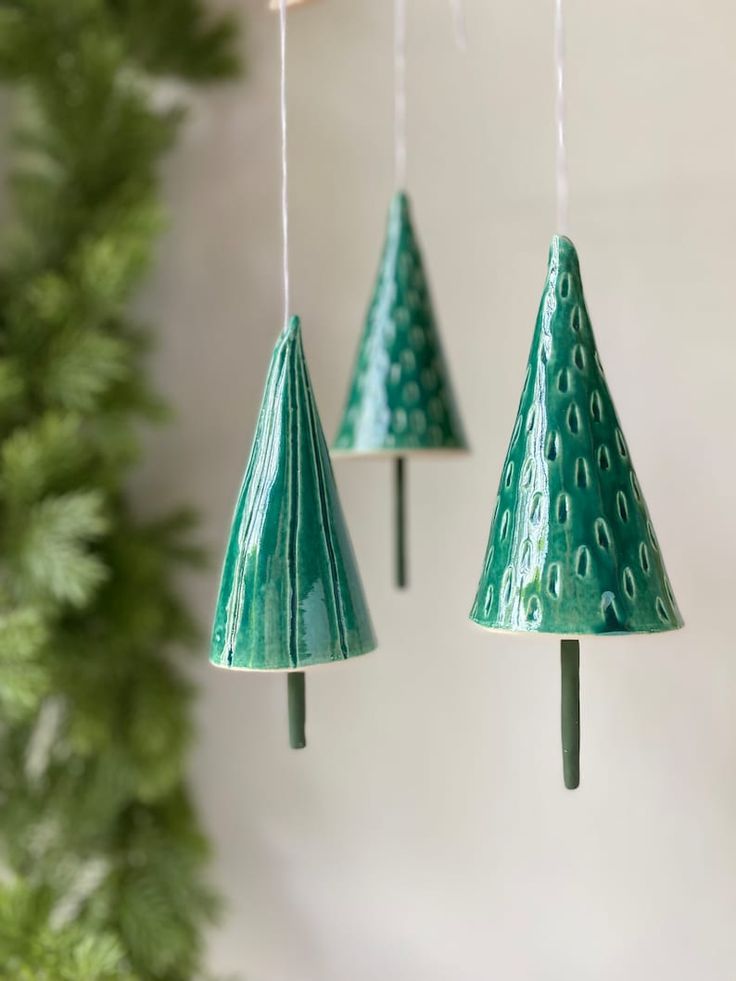 three green christmas trees hanging from the ceiling