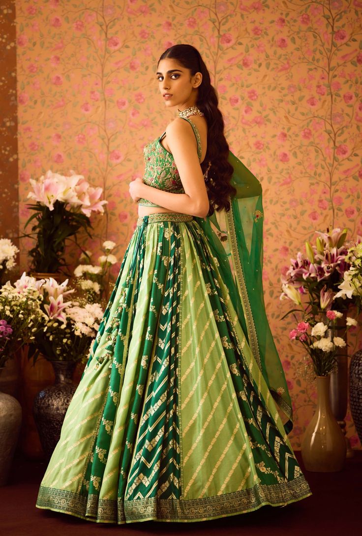 Step into refined elegance with the jasper green hand-embroidered silk brocade blouse, beautifully paired with a multi-panel brocade lehenga. This exquisite ensemble features intricate embroidery that enhances the luxurious fabric, while the lehenga adds depth and flair. An embroidered belt cinches the waist, and the matching dupatta completes the look, making it a perfect choice for festive celebrations and special occasions. Brocade Lehenga, Brocade Blouse, Green Lehenga, Brocade Blouses, Embroidered Belt, Casual Tunics, Green Hand, Luxurious Fabric, Silk Brocade