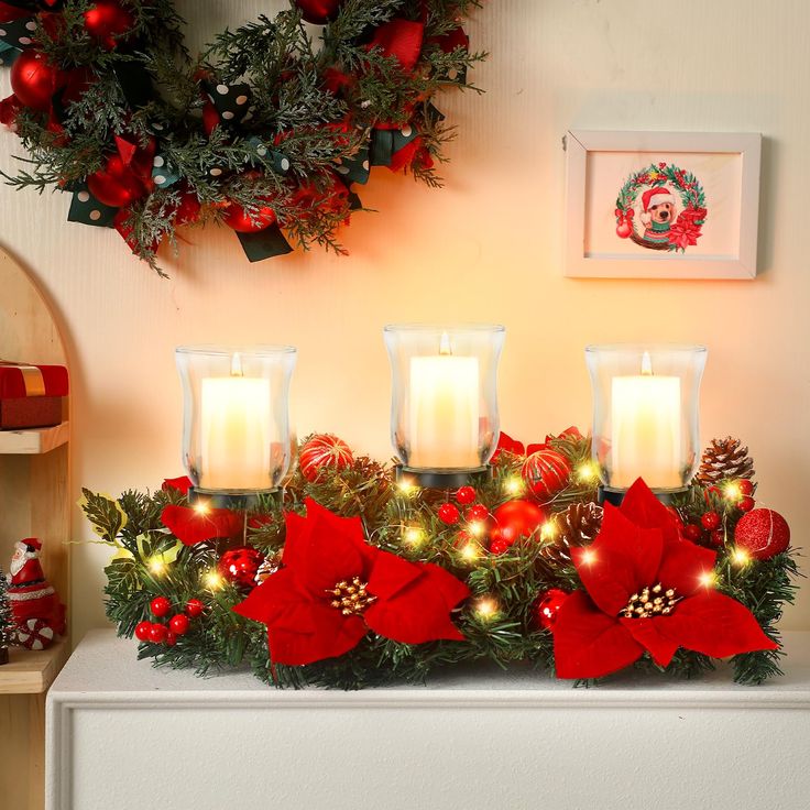 christmas decorations with candles and poinsettis on a mantle