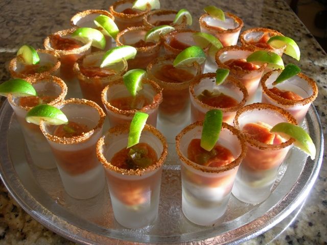 small cups filled with different types of appetizers on a platter at a party