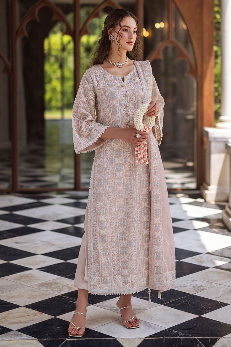 Create a striking statement in Swara this season, featuring a raw silk shalwar and a chikankari embroidered shirt adorned with light sequins, pearl hanging buttons, and milky lace accents on the border and sleeves. The look is complete with a dupatta that showcases four-sided chikankari borders. This is a 3 pc outfit. Lucknavi Suits Design, Lakhnowi Suits Design, Lukhnowi Suits Design, Chikenkari Dress Ideas, Roka Outfits, Lucknowi Chikankari Suits, Shirt Kurti, Simple Indian Suits, Pakistani Clothes Online