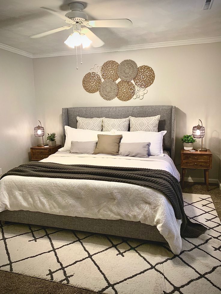 a bedroom with a bed, rug and ceiling fan