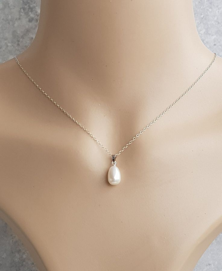 A beautiful and simple solitaire white freshwater pearl pendant on an 925 sterling silver trace chain. U.K Hallmarked 8mm x 11.5mm half drilled white freshwater pearl very good lustre  925 sterling silver bail clip and a 18inch sterling silver chain The pearls I use is are genuine freshwater pearls therefore each pearl is slightly different in shape and size and each pearl has its own unique natural blemishes. All measurements mentioned in this listing is approximate  Will be sent in a gift box Simple Sterling Silver Jewelry For Formal Occasions, Pear-shaped White Gold Sterling Silver Necklace, Sterling Silver Drop Jewelry With Pearl Charm, Classic Pearl Teardrop Pendant Jewelry, Dainty Sterling Silver Pearl Necklace With Round Pendant, Simple Silver Necklace With Pearl Pendant, Delicate Silver Pear-shaped Jewelry, Sterling Silver Jewelry With White Pearl Charm, Classic Pearl White Teardrop Pendant Jewelry