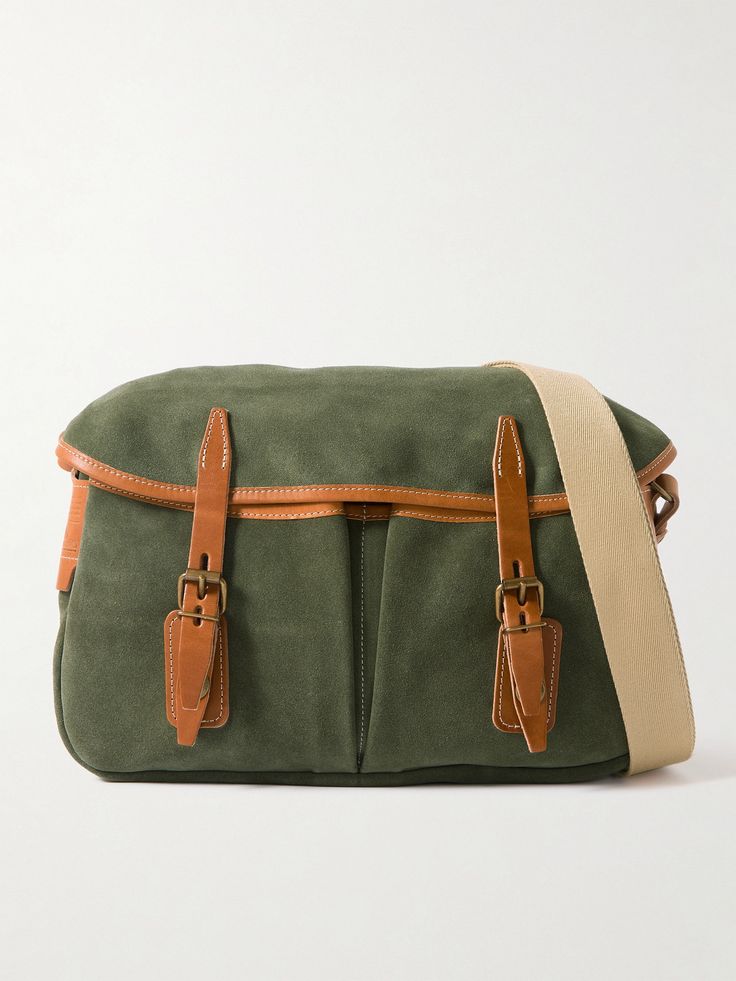 Bleu de Chauffe's messenger bag is modelled on a traditional fisherman's musette. Made at the brand's workshop in France, it's crafted from smooth green suede with brown leather buckle fastenings and a durable canvas strap. It opens up to a spacious compartment that's fitted with a zip pocket to keep your phone or cardholder secure. Luxury Green Canvas Shoulder Bag, Green Leather Shoulder Bag With Leather Trim, Green Leather Trim Crossbody Shoulder Bag, Green Leather Bag With Leather Trim, Green Leather Bags With Leather Trim, Green Satchel Bag With Leather Trim, Luxury Green Shoulder Bag With Leather Trim, Green Satchel Shoulder Bag With Waxed Finish, Green Waxed Finish Satchel Shoulder Bag