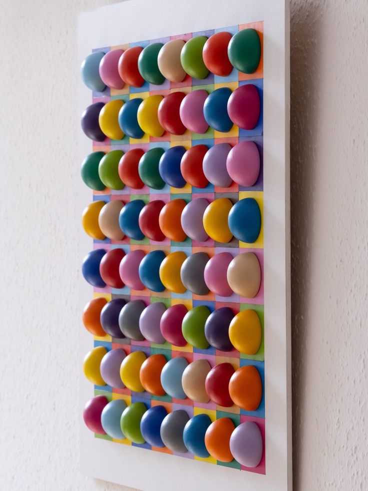 a multicolored art piece hanging on the wall