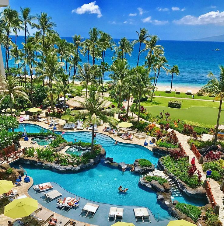 an aerial view of a resort pool and beach