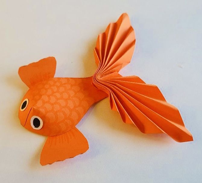 an origami goldfish on a white surface