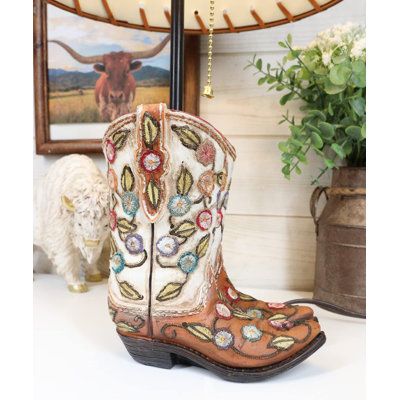 This western boots table lamp comes with the shade as pictured. Made of polyresin, hand-painted and polished, the quality finish is superb! The shade is made of laced paper textured in a leather-like finish. The top and bottom fringes of the shade has lace stripes. Foundry Select | Foundry Select Figurine 19.0 H x 12.0 W x 12.0 D in brown / orange / pinkResin / Paper in Blue;orange | 19" H X 12" W X 12" D | Wayfair Tan Cowgirl Boots, Retinol For Acne, Desktop Table, Retinol Eye Cream, Western Rustic, Embroidery Hand, Brown Shades, Tooled Leather, Christmas Wishlist