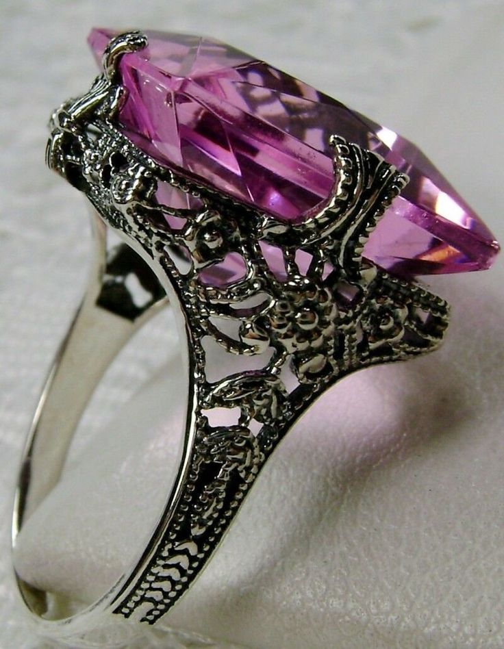 Simulated Pink Topaz Ring SquareVic Design#77 Made To Order This is a brand new Victorian era reproduction floral filigree ring in sterling silver. The rare filigree ring is set with a high-quality man-made/simulated pink topaz. The gemstone is 15mm (about 9/16th of an inch) in length and 15mm in width. The rings stand about 8mm off the finger. The inside of the band is marked 925 for sterling. This is a lovely new, well-made ring and it is ready to wear. A ring gift box included and all rings a Exquisite Silver Amethyst Ring For Wedding, Exquisite Filigree Ring For Formal Occasions, Exquisite Amethyst Wedding Ring, Exquisite Oval Filigree Ring, Amethyst Rings With Intricate Design For Wedding, Pink Rings With Intricate Design For Anniversary, Antique Filigree Ring With Center Stone As Gift, Victorian Amethyst Ring With Center Stone As Gift, Victorian Amethyst Ring With Accent Stones For Formal Occasions