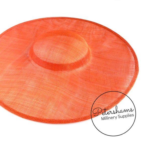 This orange cartwheel hat base is a classic shape that has sprung into popularity in the past year. Made from 2 layers of stiffened sinamay, these cartwheels are ready to trim and are fitted with a petersham ribbon on the inside crown edge. Simply add a comb or headband to secure to the head.Hat base measures:Width: 35.5cm (14 inches)Crown Width: 13.5cm (5.3 inches)Crown Height: Approximately 3.5cm (1.7 inches)For even more millinery supplies you can find us here:www.etsy.com/shop/PetershamsAll Adjustable Orange Straw Hat With Curved Brim, Orange Sun Hat With Curved Brim, Orange Curved Brim Sun Hat, Orange Adjustable Hat With Curved Brim, Orange Brimmed Straw Hat With Adjustable Fit, Adjustable Orange Hat With Curved Brim, Adjustable Brimmed Orange Straw Hat, Adjustable Brimmed Orange Hat, Adjustable Orange Brimmed Hat