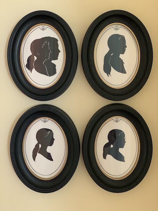 four framed silhouettes of people are on the wall