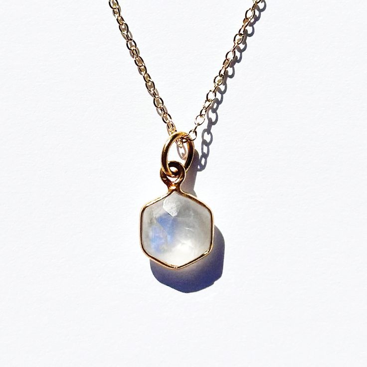 The women's necklace has a white moonstone. Moonstone is a stone symbolizing inner development and power that is associated with "new beginnings." It calms emotions and reduces emotional instability and tension. Moonstone encourages inspiration, prosperity, and good fortune in love and business. Material: 18K Gold Plated, 925 Sterling SilverGemstone: Natural MoonstonePendant Size: 8mm longChain Length: 18" chain Chain Type: CableClasp Style: Spring Ring Spiritual Moonstone Birthstone Necklace, Moonstone Necklaces With Natural Stones For Meditation, Moonstone Necklaces For Meditation With Natural Stones, White Crystal Pendant Necklace With Moon Charm, White Adjustable Necklace With Moon Charm, Adjustable White Necklace With Moon Charm, Spiritual White Necklace With Moon Charm, White Spiritual Necklaces For Everyday Wear, Healing White Moon Phase Jewelry