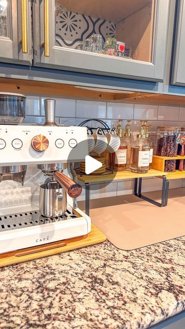 a coffee maker sitting on top of a counter next to a shelf filled with bottles