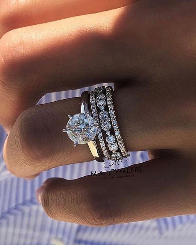 a woman's hand with a ring on it and two diamond bands around the band