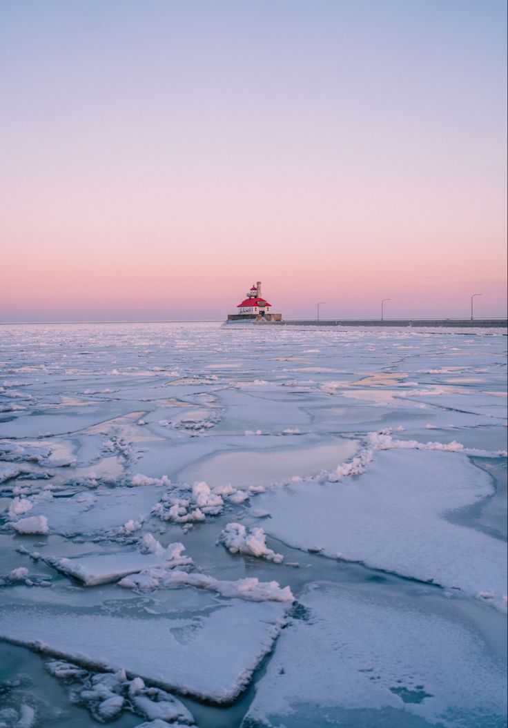 an ice floet with a light house in the background at sunset or dawn