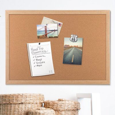 a cork board with pictures and magnets on it next to a wicker basket