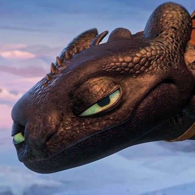 a close up of a dragon's head in the sky with clouds behind it