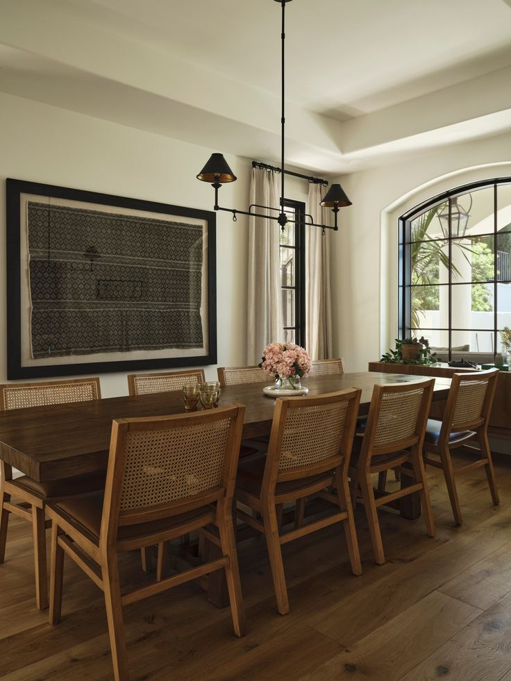 the dining room table is surrounded by wooden chairs