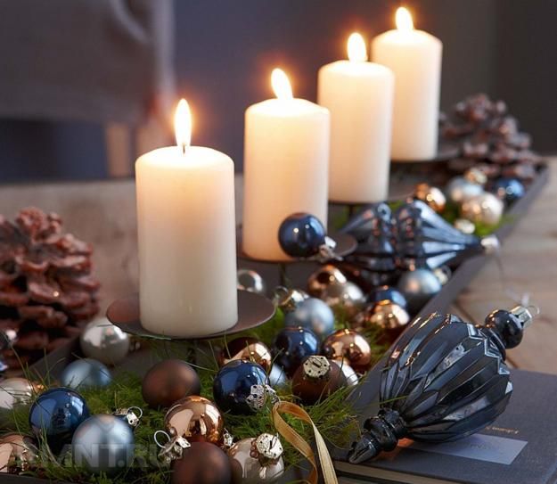 three candles are sitting on a table with christmas decorations