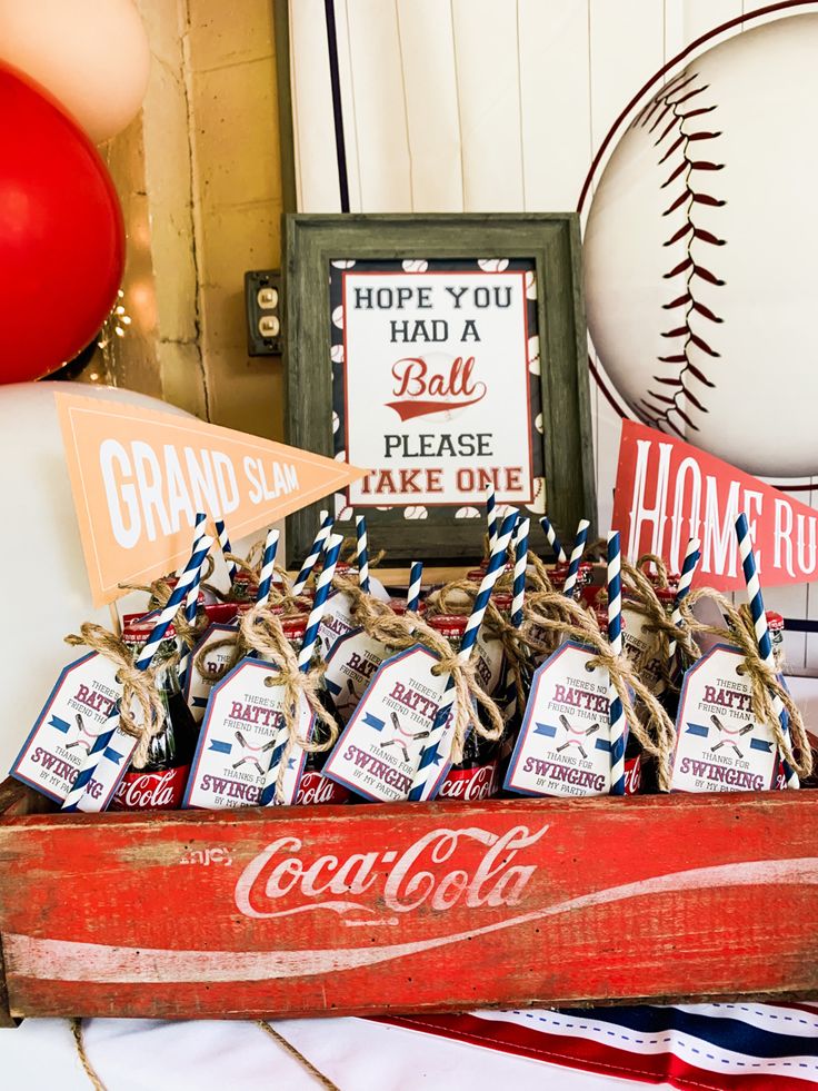 a baseball themed birthday party with coca - colas and candy bar wrappers in an old wooden crate