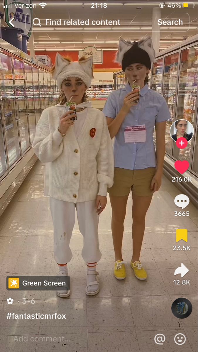 two women standing in a store looking at their cell phones