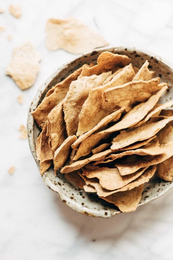 a bowl filled with tortilla chips on top of a table