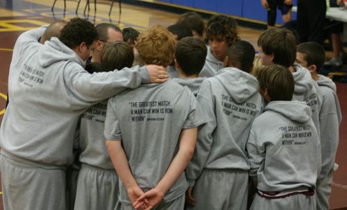 a group of young men standing next to each other on a basketball court